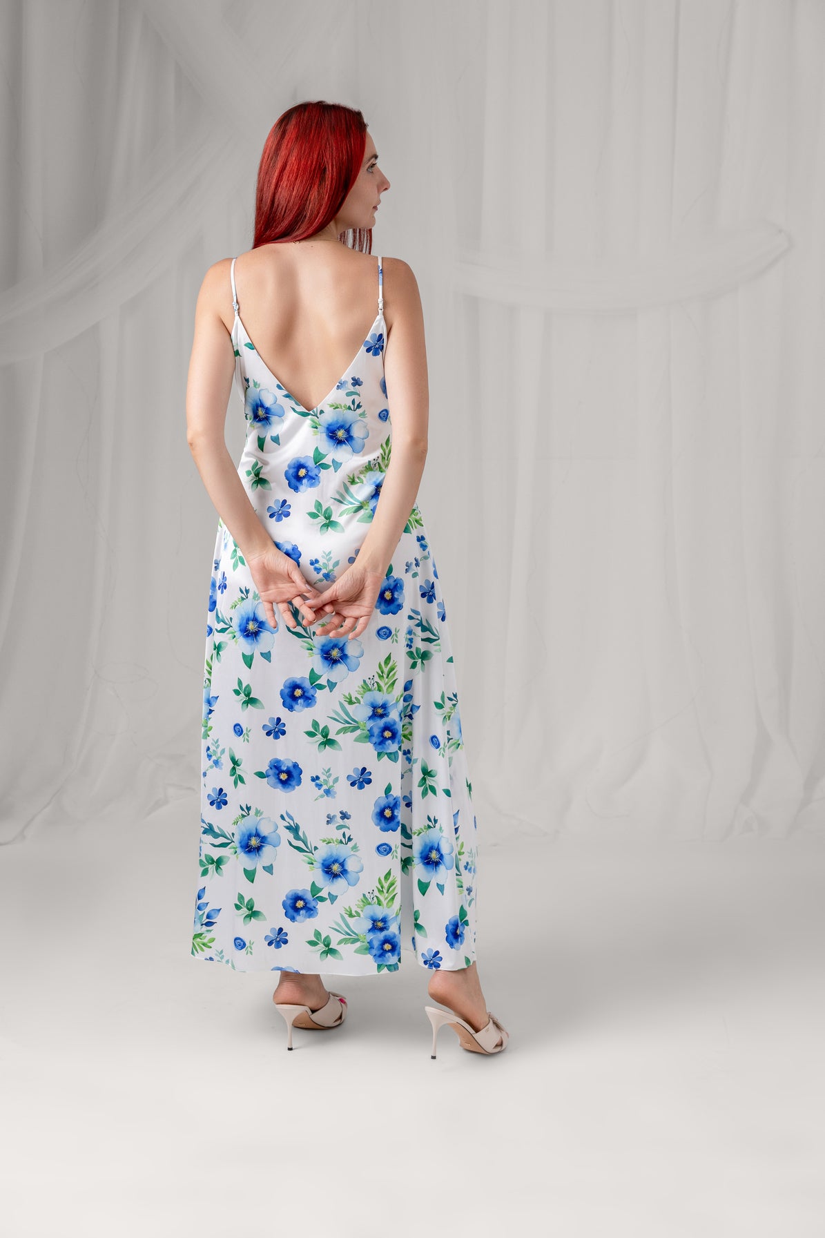 Azure Bloom white floral maxi dress with blue flowers and green leaves, full-length back view
