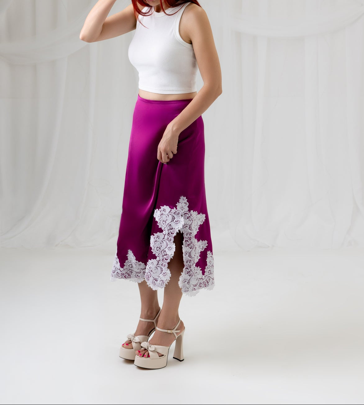House of Lluvie' burgundy satin midi skirt with lace trim, side profile view