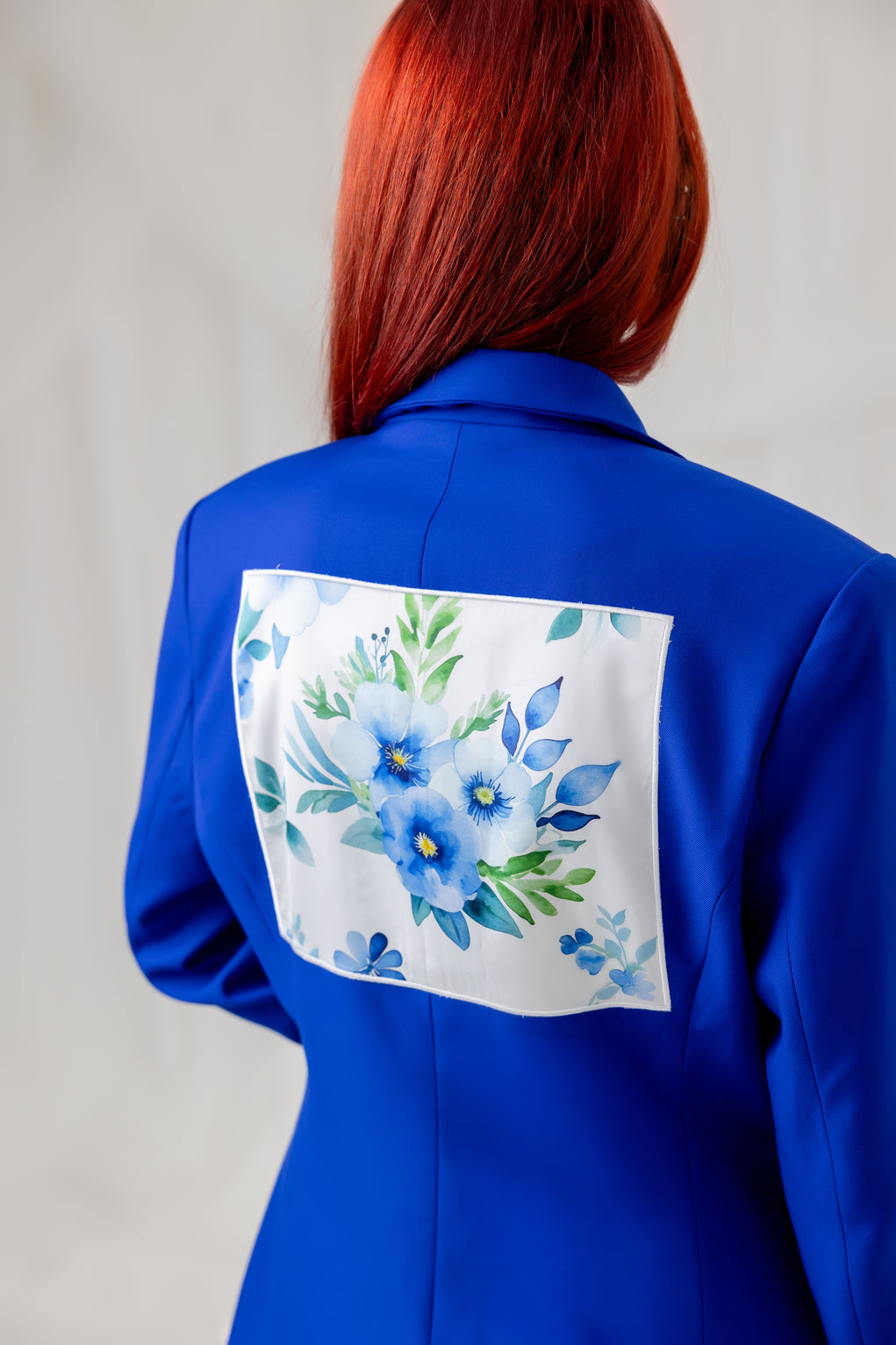 Close-up of the cobalt blue blazer back with a floral detail on back view