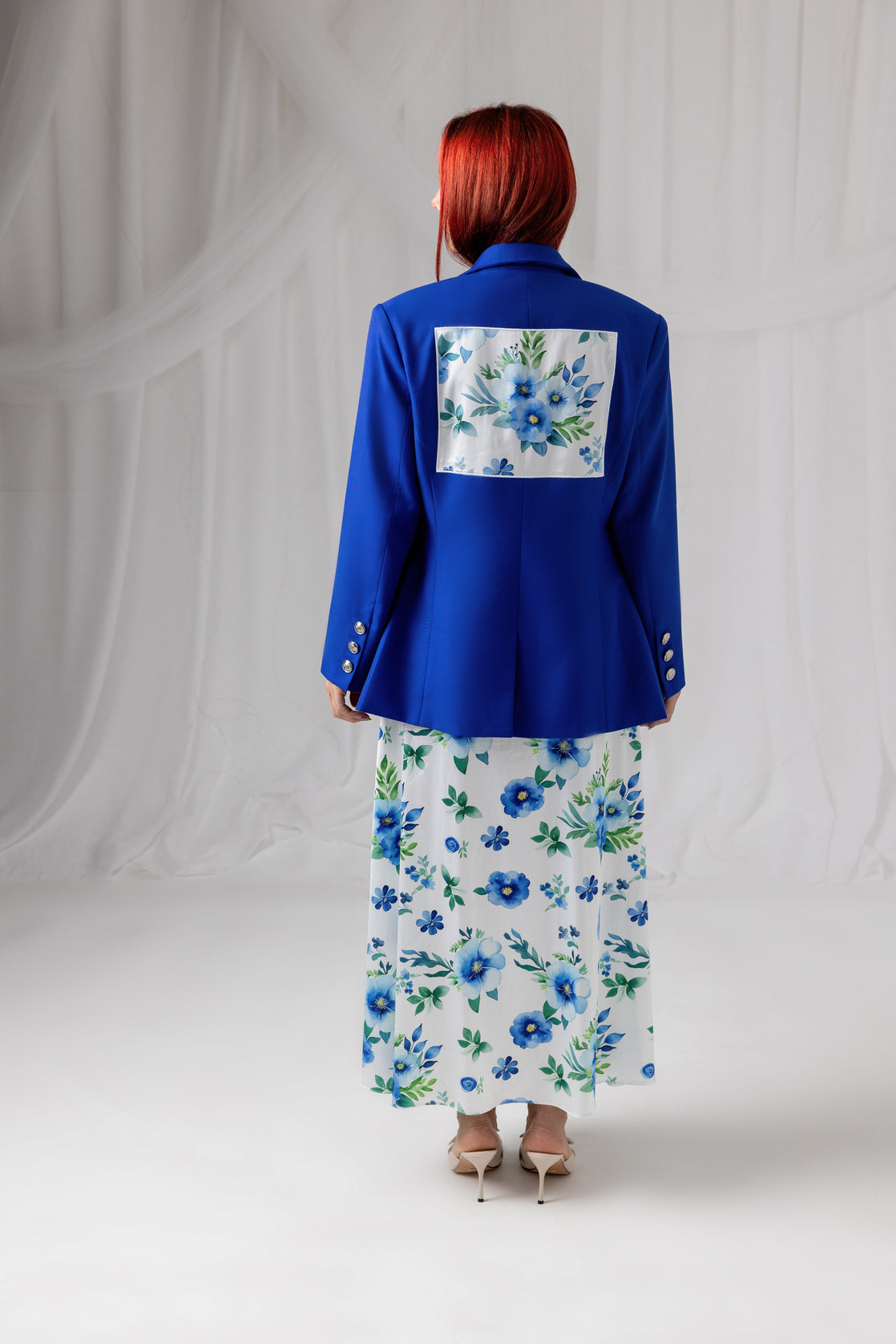 Back view of the House of Lluvie' cobalt blue blazer styled with a floral maxi dress