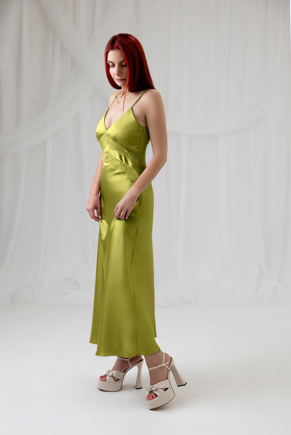 Model wearing the green satin lace dress, three-quarter front view