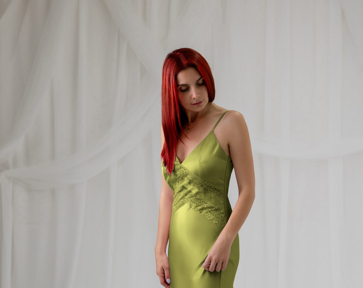 Model wearing the green satin lace dress, three-quarter front view