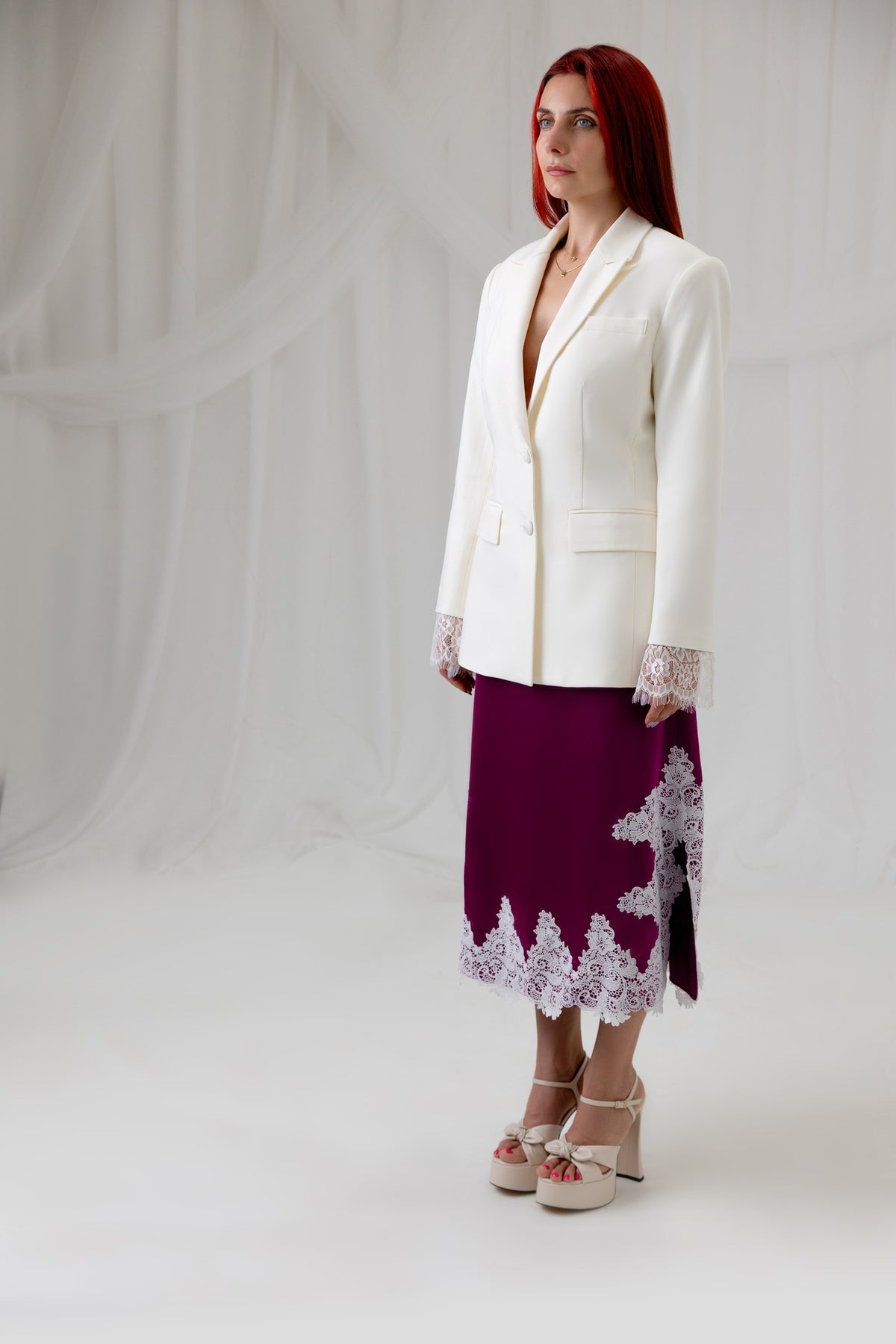 House of Lluvie' Ivory Muse Blazer styled with a burgundy lace midi skirt, three-quarter view